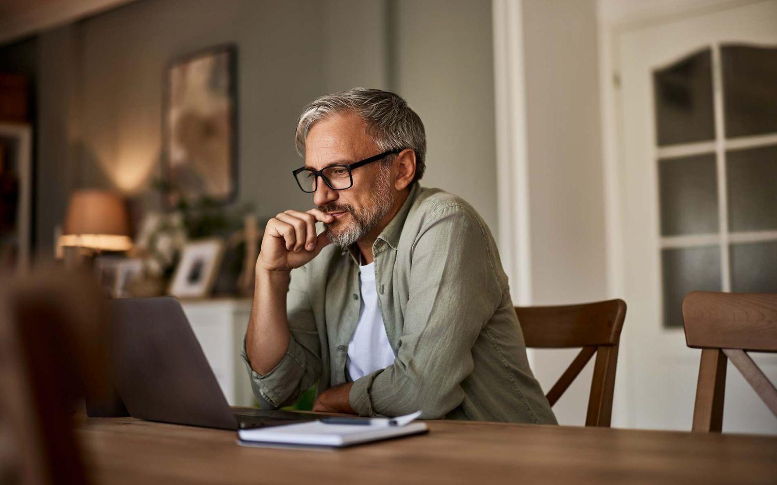Bild: Mann mit Brille liest etwas am Laptop