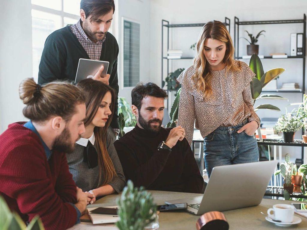 Symbolbild Insolvenzgeldumlage: Gruppe schaut auf Laptop.