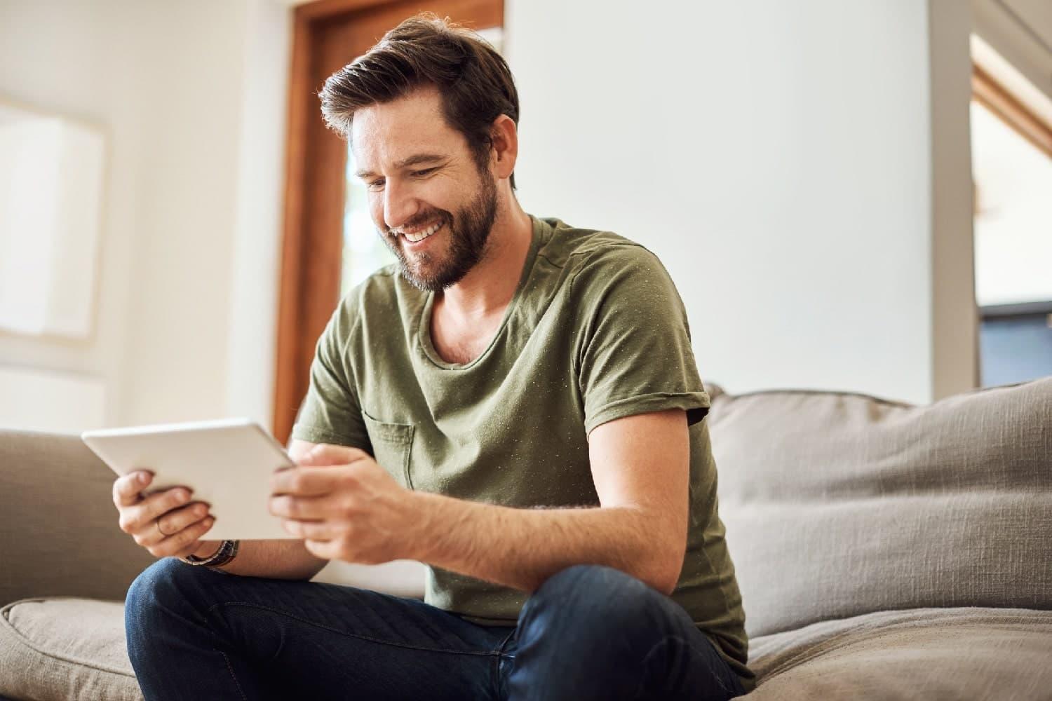 Kurberatung: Mann mittleren Alters schaut zufrieden auf ein Tablet.